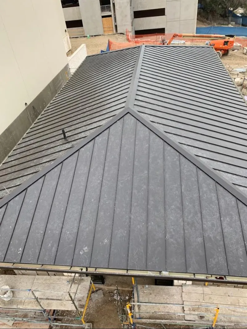 Commercial metal roof construction with crane equipment in Hays