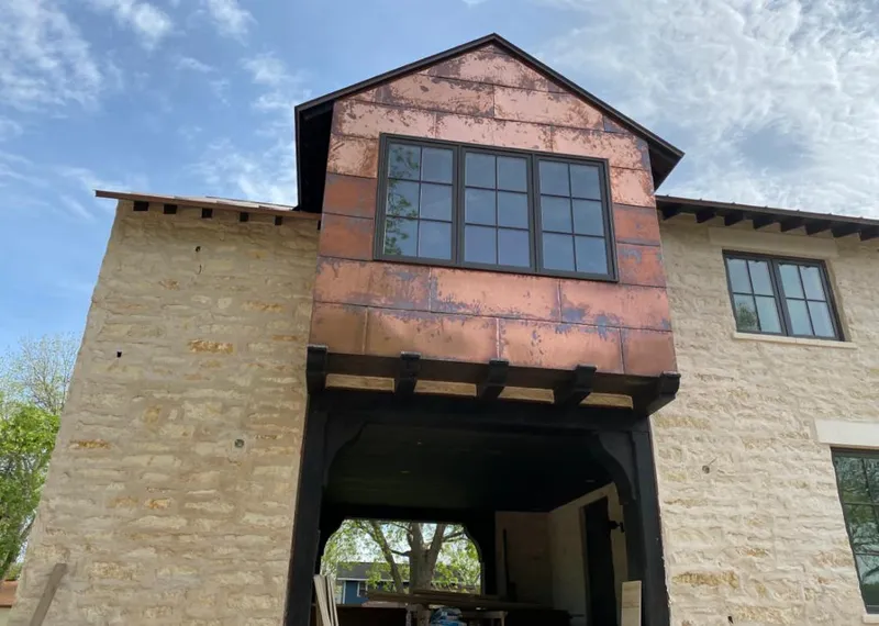 Copper metal panel facade on a stone building for Roof Repair in Hays